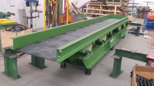 Factory testing of vibrating conveyor for castings.