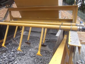 Vibrating screen with spray bars on mine site.